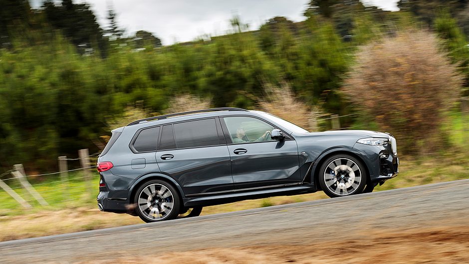 BMW X7 SUV side driving around corner