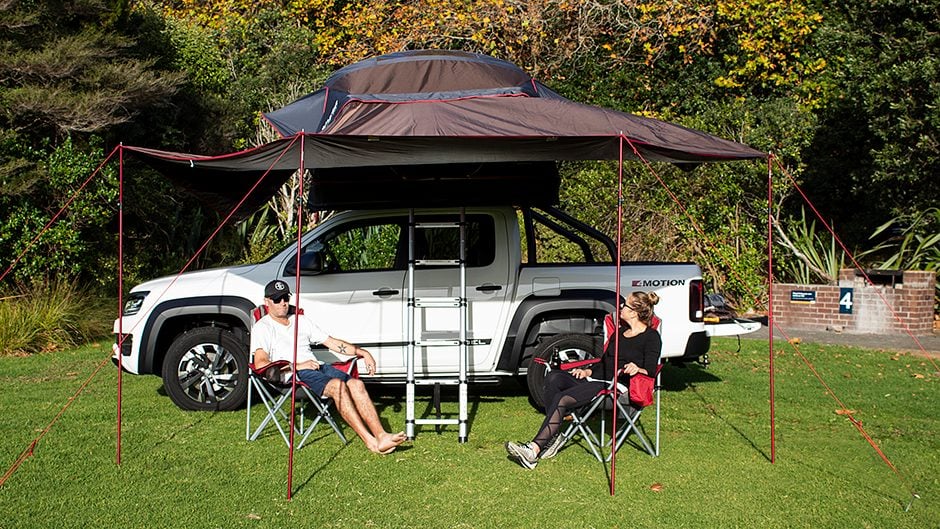 iKamper Rooftop tent mounted on VW Amarok with adults relaxing outside