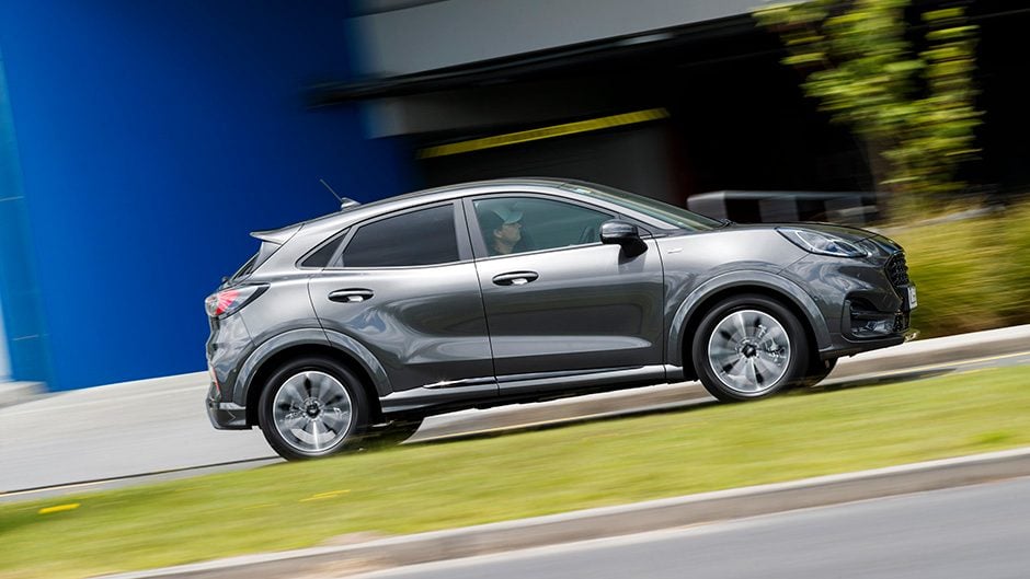 Ford Puma driving past buildings