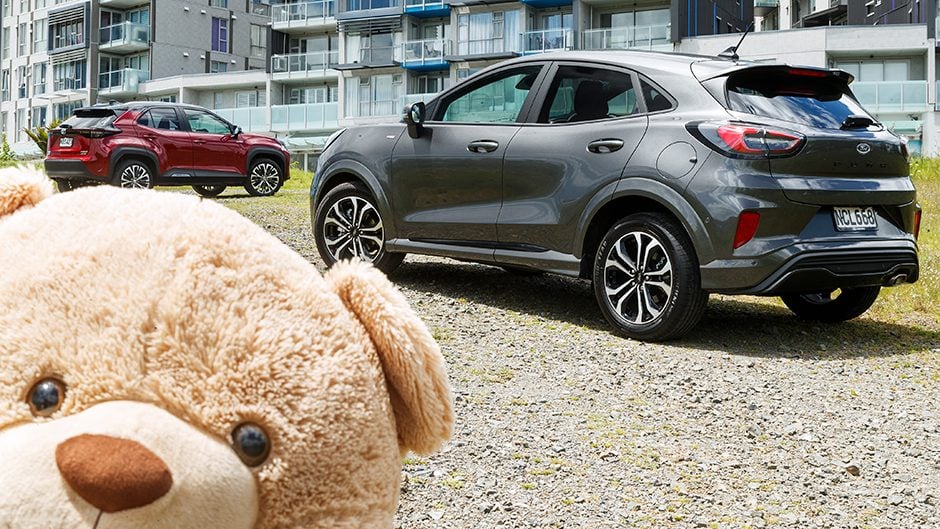Ford Puma vs Toyota Yaris Cross in front of apartments
