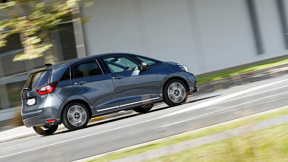Honda Jazz e:HEV Luxe driving past shops