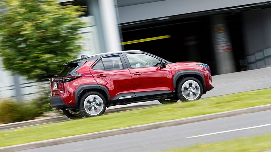 Toyota Yaris Cross driving past buildings
