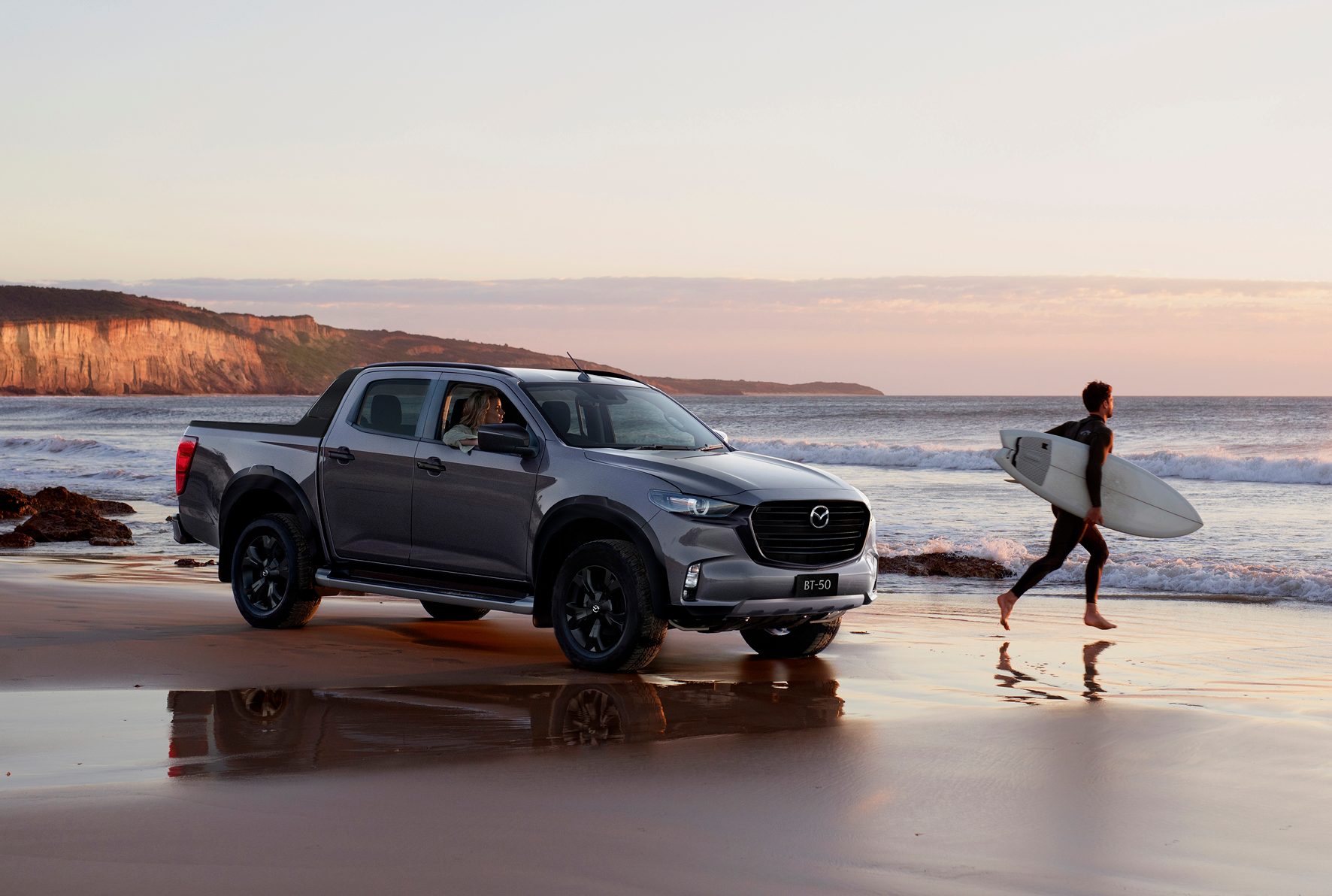 Mazda BT-50 front three quarters on beach with surfer