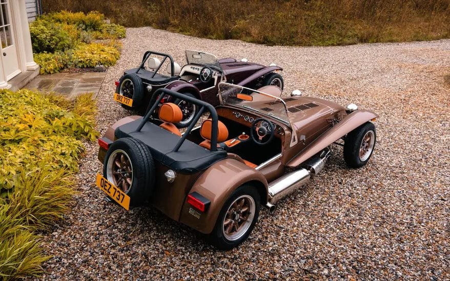 Two Caterham Super Sevens parked next to each other rear three quarter view