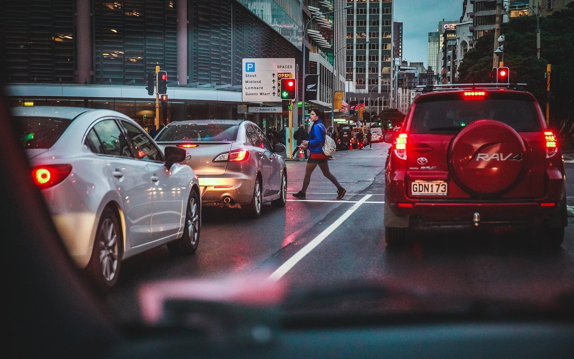 Woman crossing road with traffic waiting