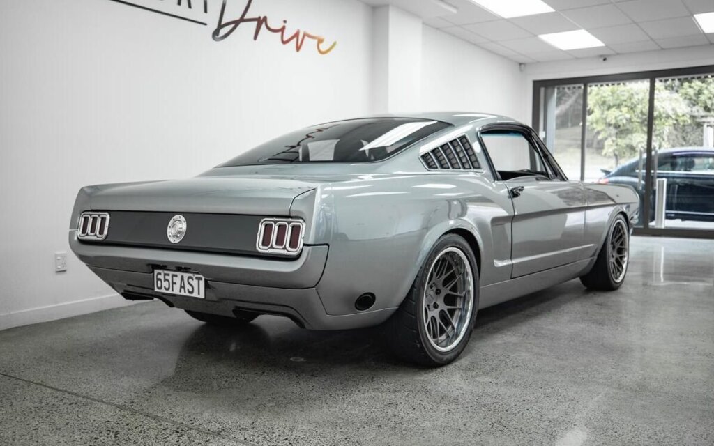 1965 Ford Mustang Fastback rear three quarter view in dealership