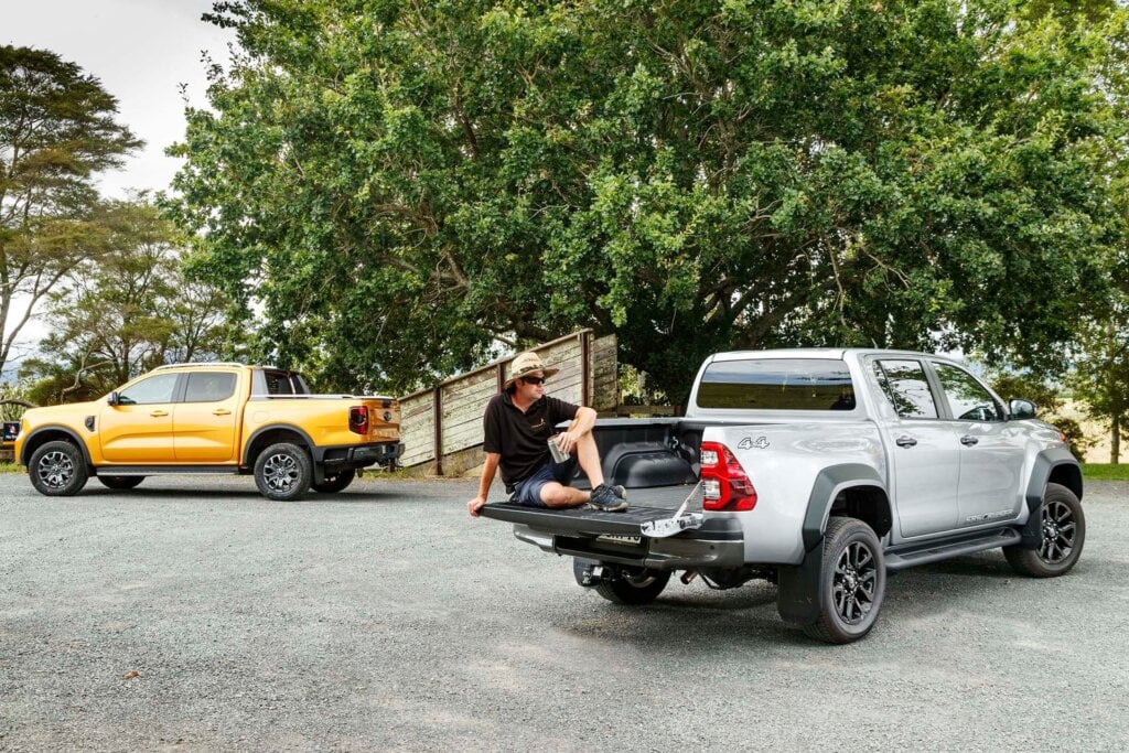 Ford Ranger Wildtrak vs Toyota Hilux SR5 Cruiser rear static with dude