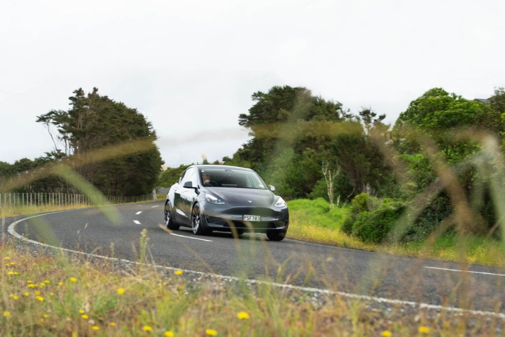 Tesla Model Y takes a corner on a backroad