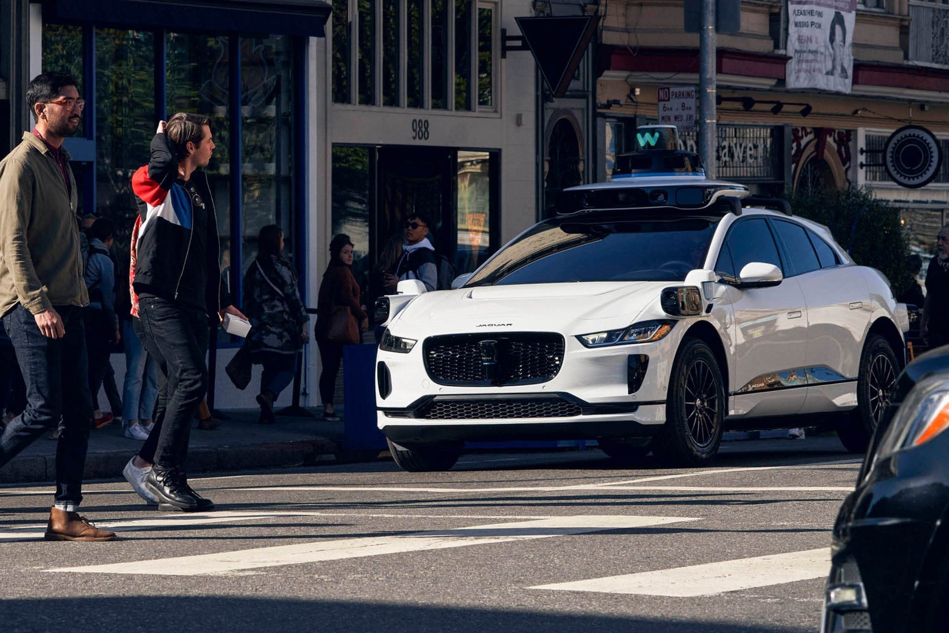 Waymo Jaguar I-Pace driverless taxi stopped at pedestrian crossing