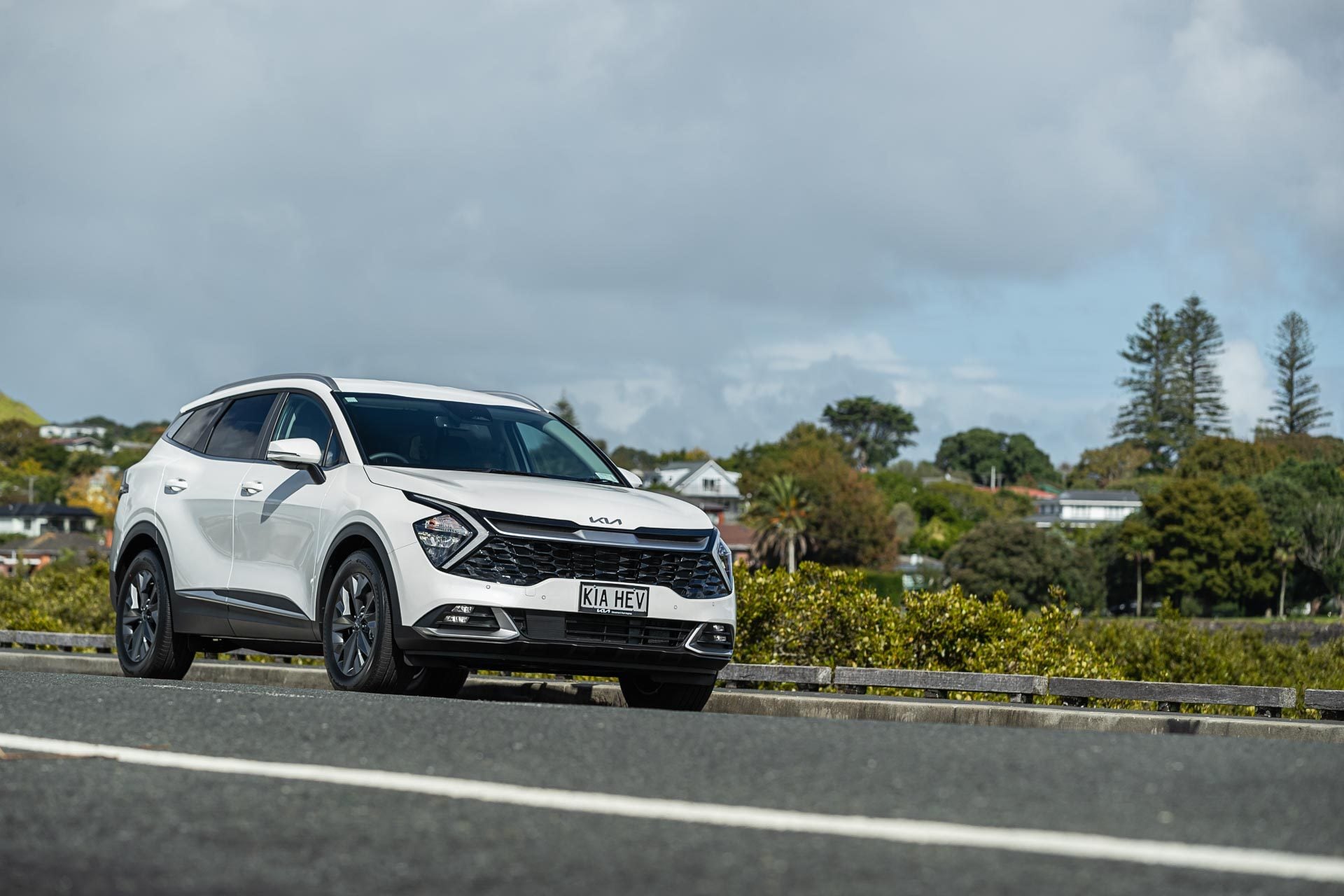 Kia Sportage HEV Earth front quarter hero image, in white