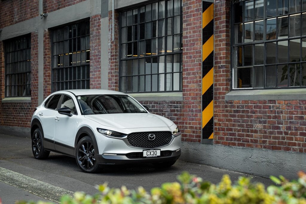 Mazda CX-30 SP25 front quarter shot, with brick wall behind