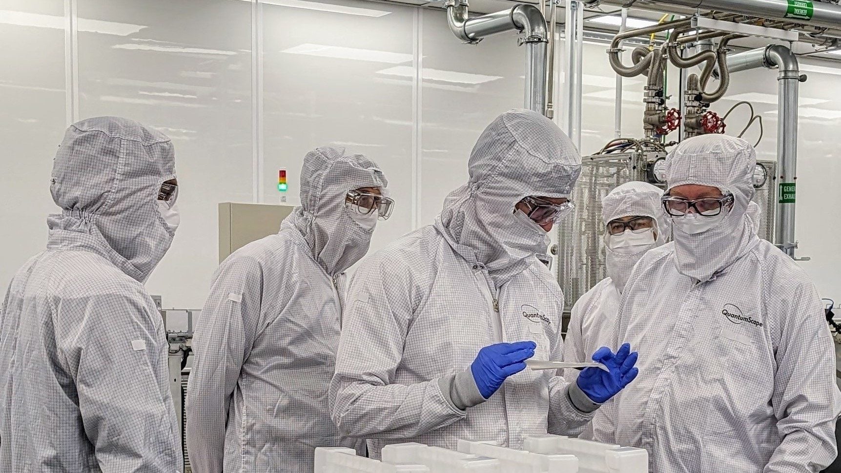 Scientists show VW exec the inner workings of their solid-state battery.