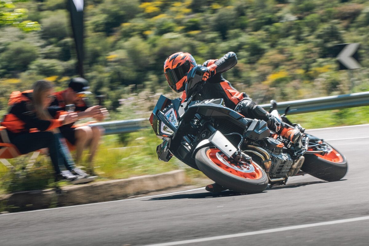 KTM not crashing but looking like it is. Spectators more interested in their phones.