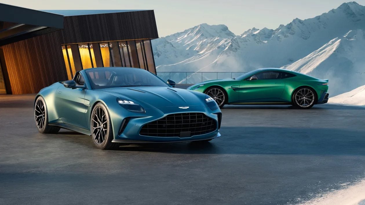 Astons parked outside stylish alpine building.