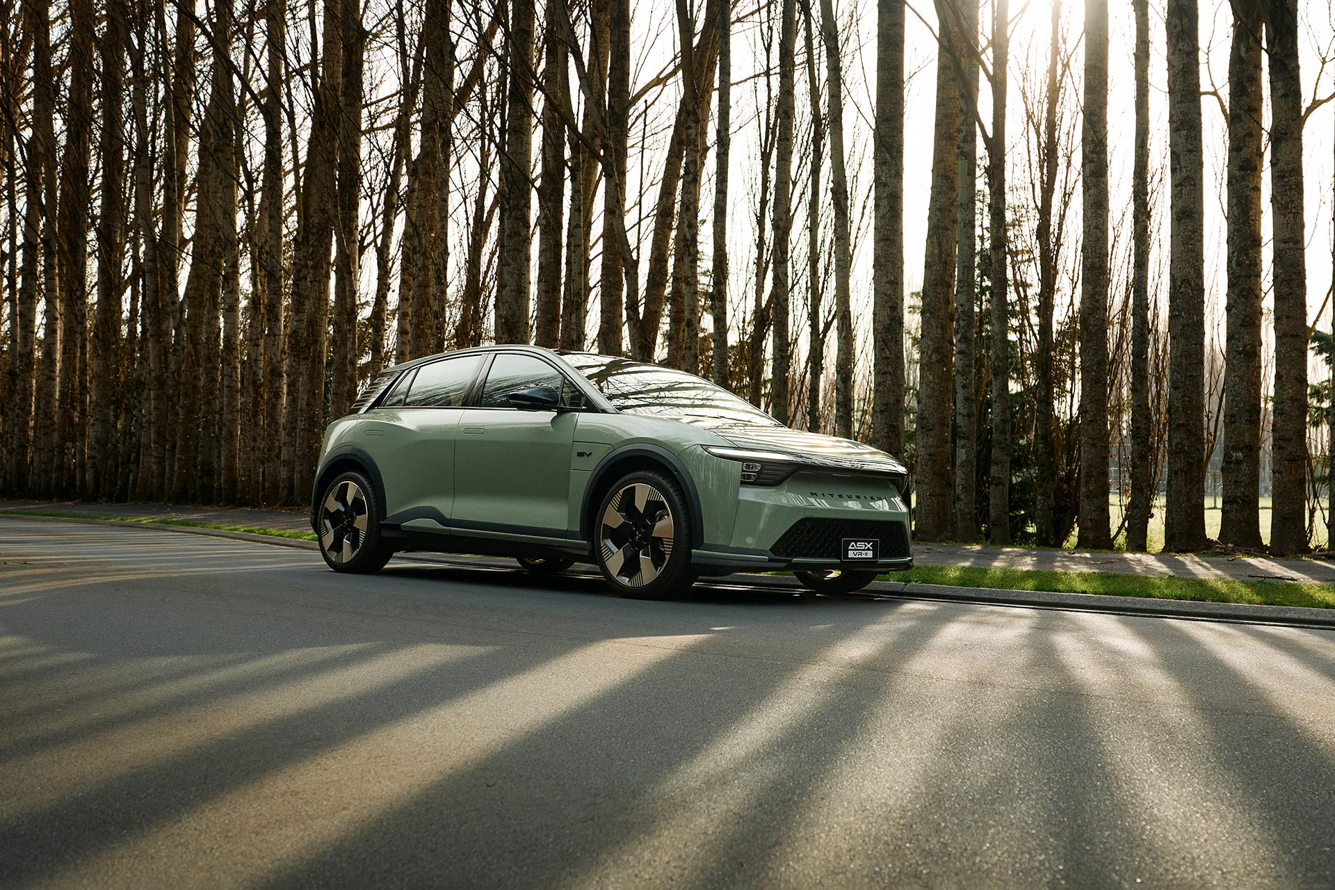 green mitsubishi in front of trees