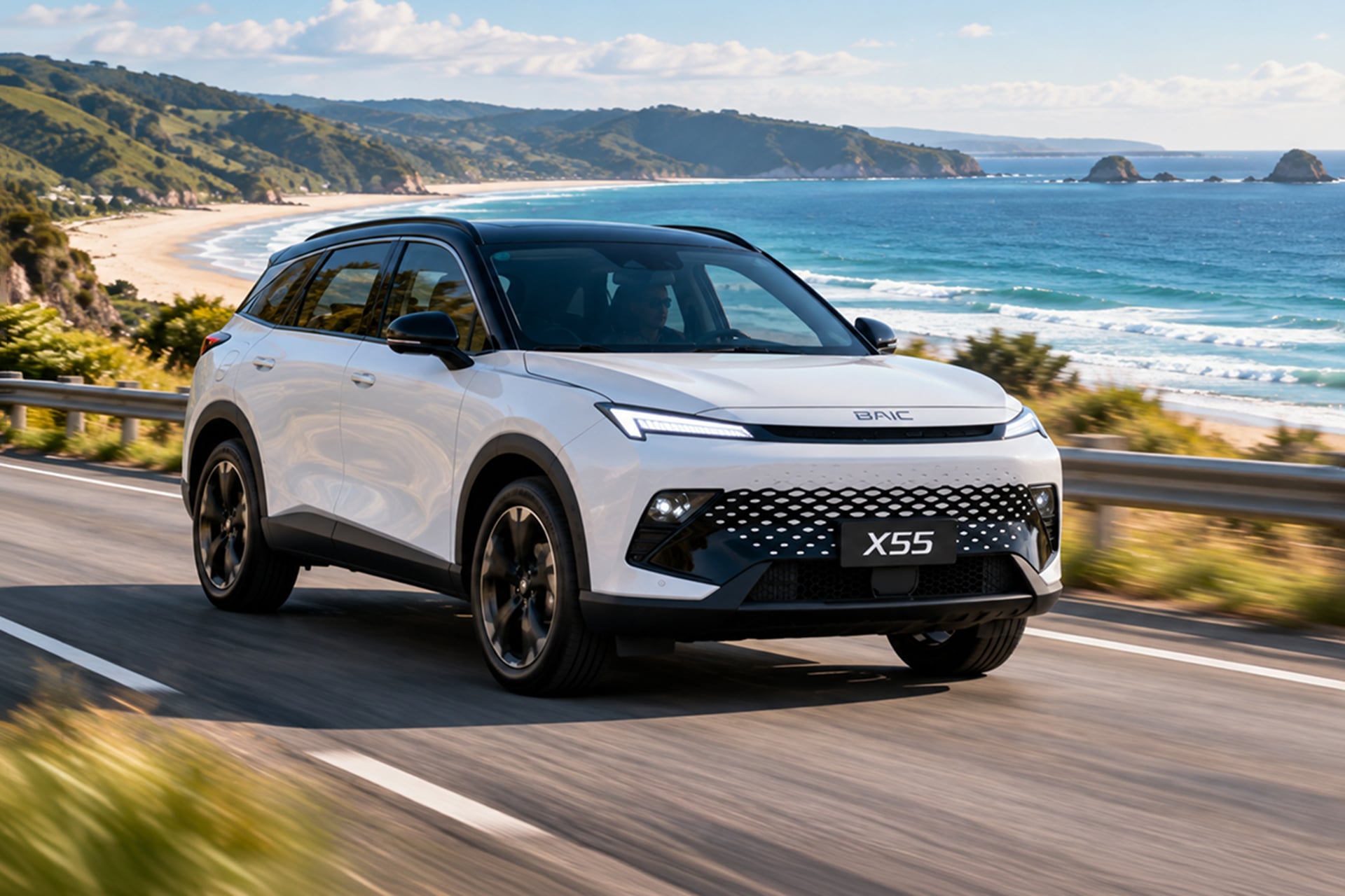X55 in white driving on a coastal road with the sea in the background