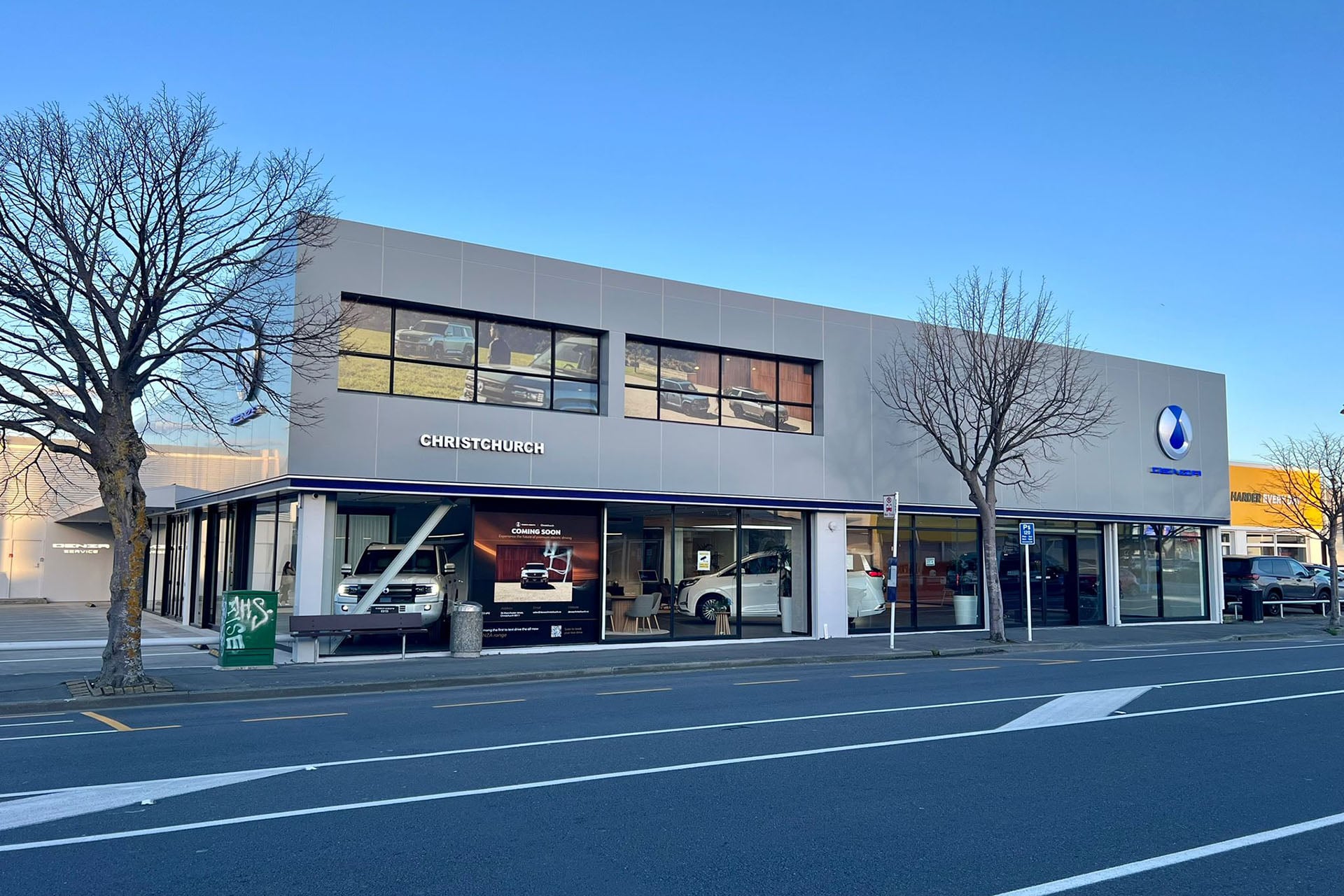 a grey car dealership under blue skies