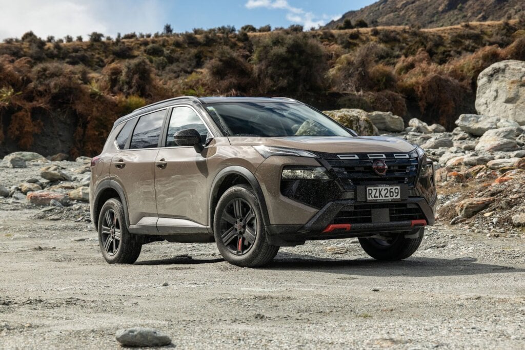 2026 Nissan X-Trail Rock Creek front three-quarter view showing black grille, orange accents and 18-inch alloys