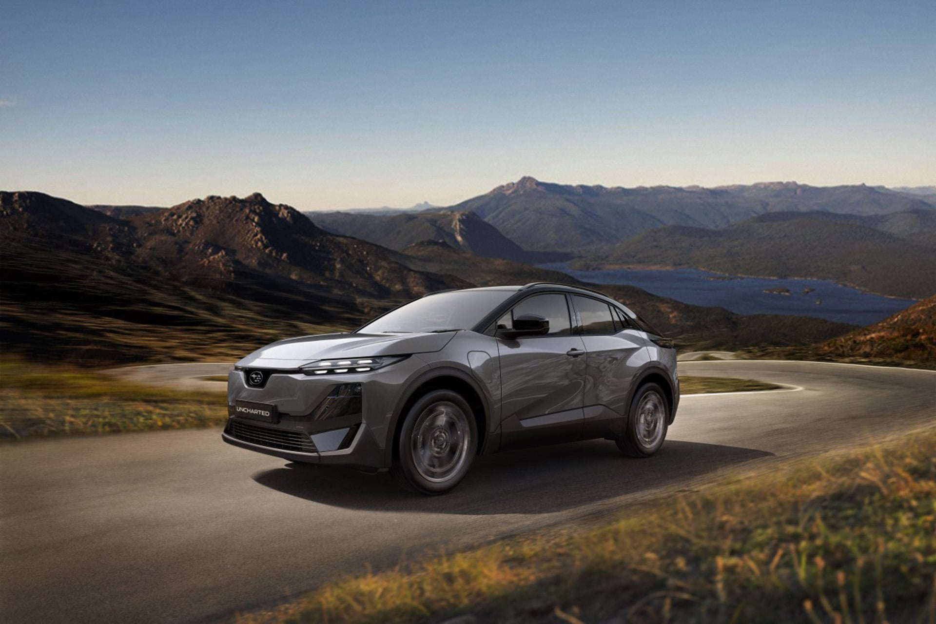 grey Subaru o country road in front of mountains