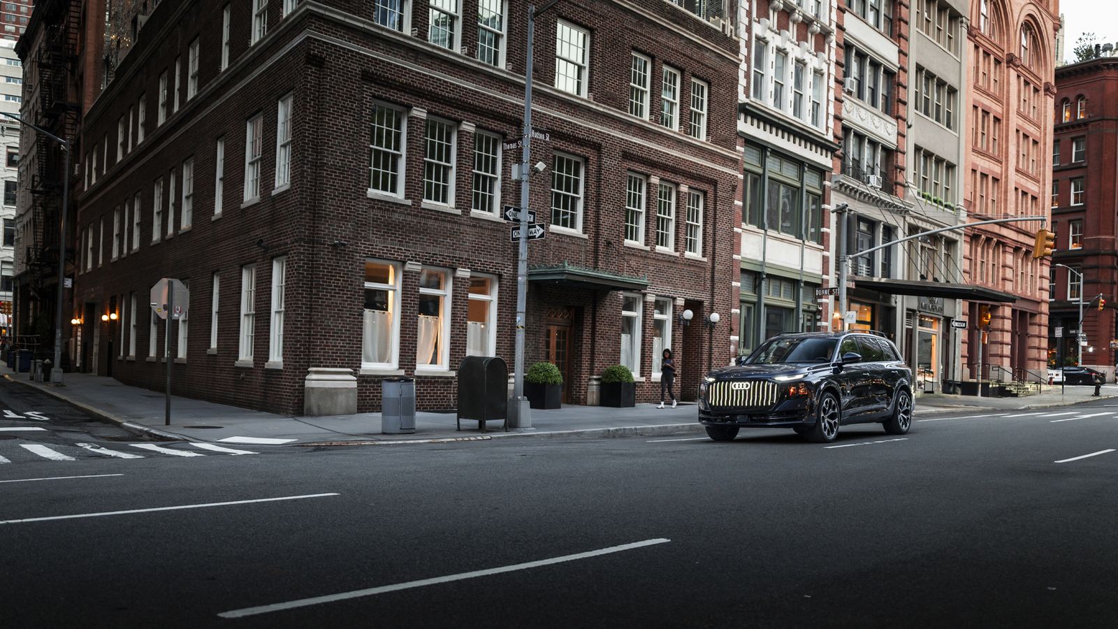 Front view of the Audi Q9 flagship SUV driving on a city street