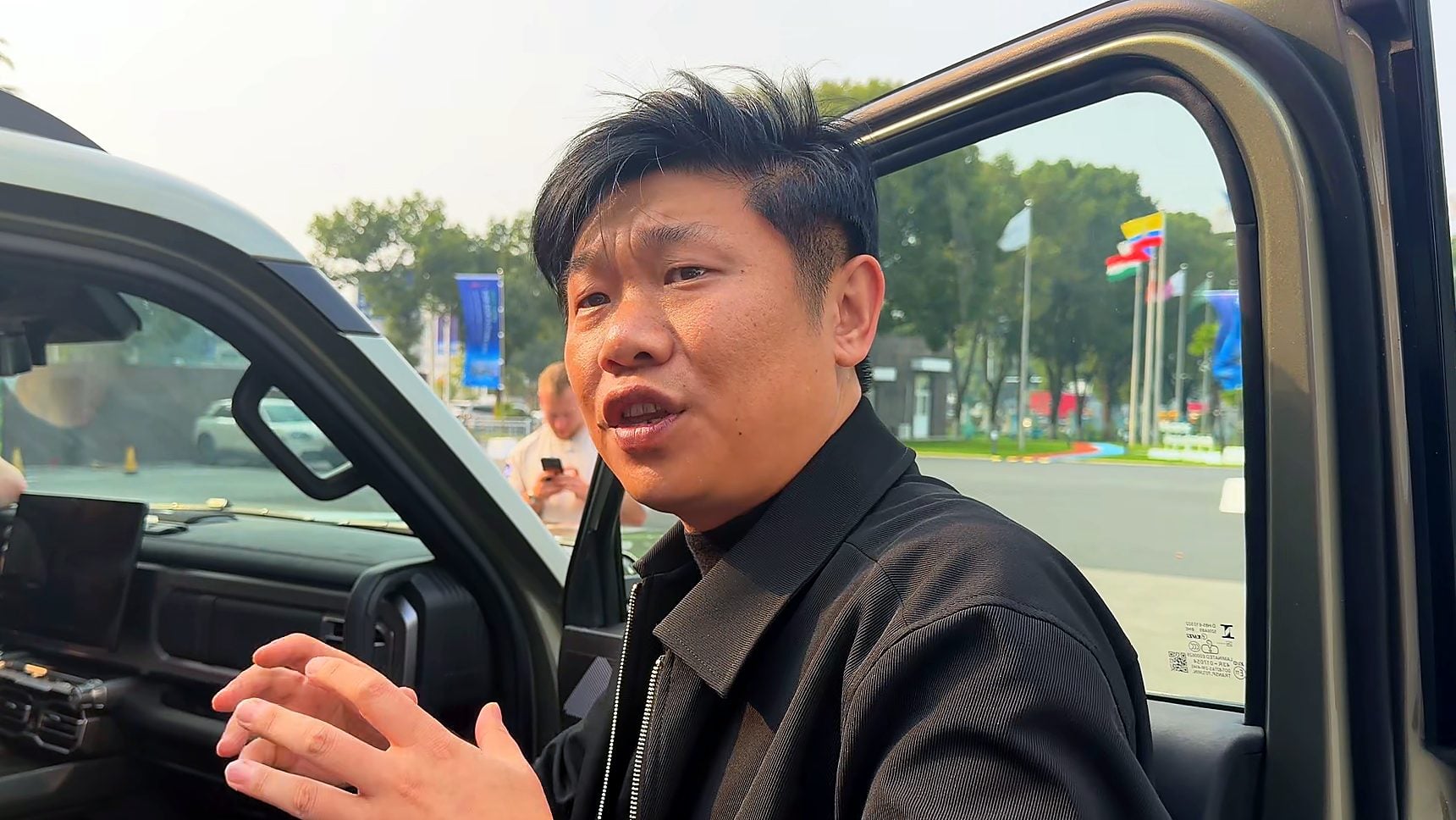Mark Qi at the open door of the Chery Stockman explaining the interior