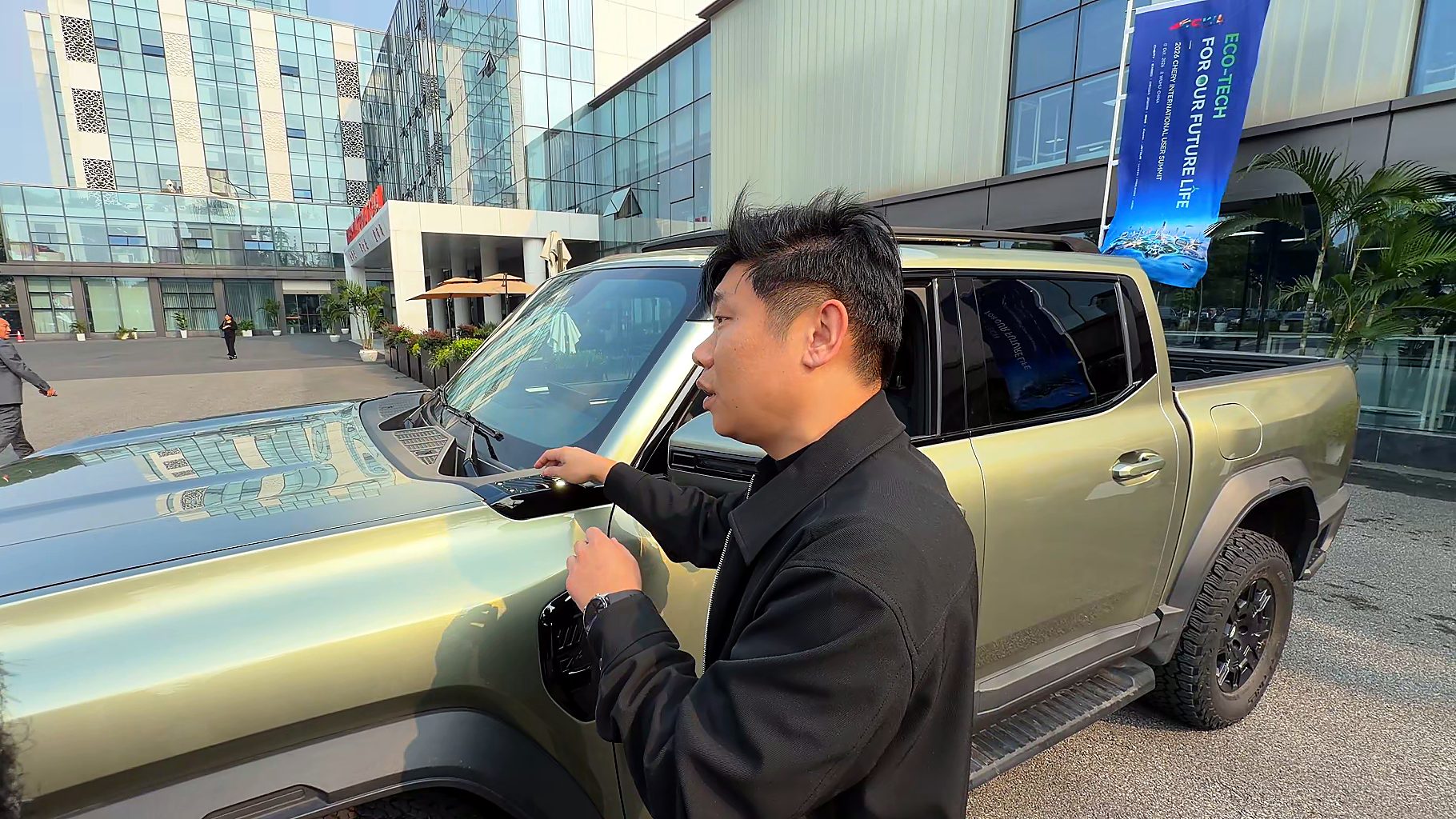 Chery Stockman chief engineer Mark Qi pointing out accessory mounting points at the base of the windscreen