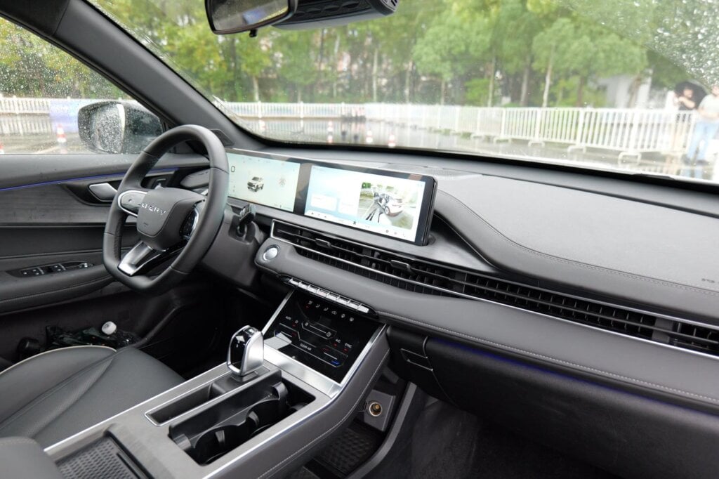 Dashboard of the 2027 Chery Tiggo 4 Hybrid facelift with twin screens, full-width air vents and stitched dash trim