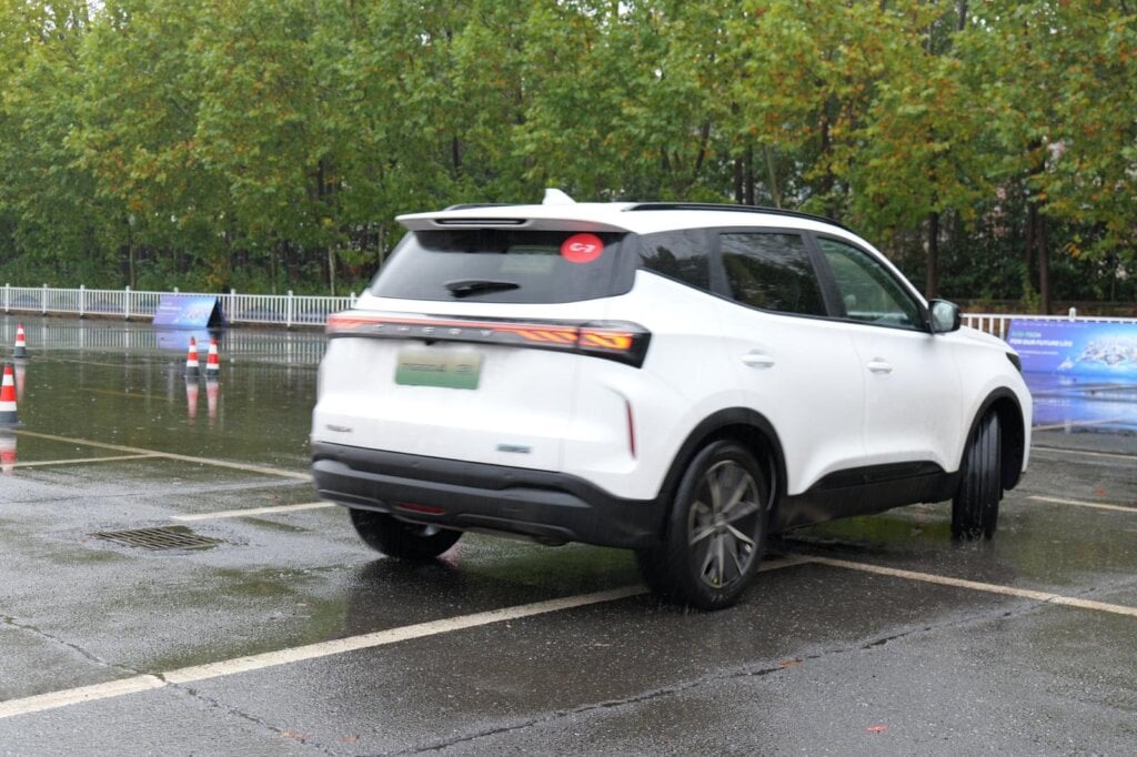 Rear three-quarter view of a white 2027 Chery Tiggo 4 Hybrid facelift on a wet test course in Wuhu, China