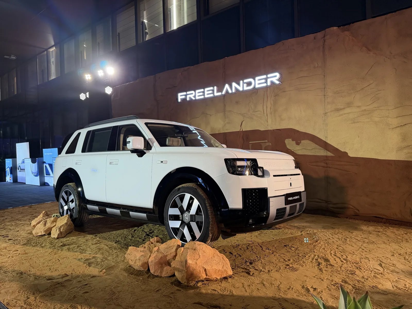 White Freelander 8 SUV front three-quarter view on a sand display at the Wuhu international launch
