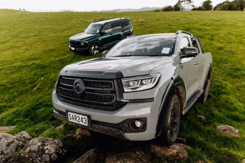 Front view of a GWM Cannon Hi4-T PHEV driving over rocks