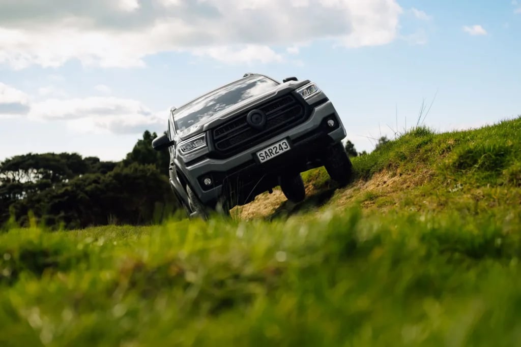GWM Cannon Hi4-T PHEV climbing a steep grassy slope off road