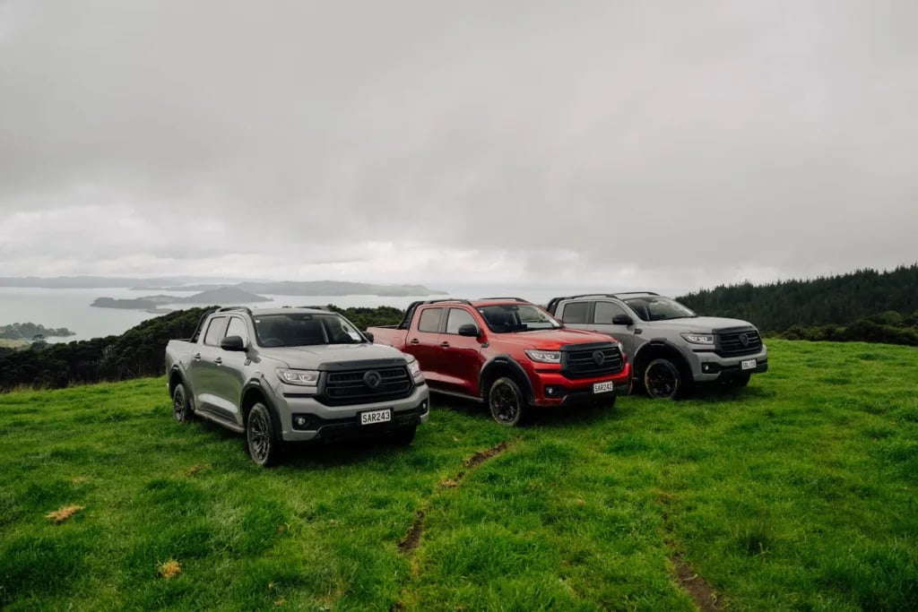 Three GWM Cannon Hi4-T PHEV utes parked on a coastal hilltop