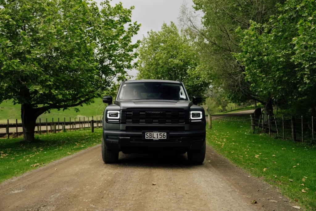 Front view of the Haval H7 on a tree-lined gravel road