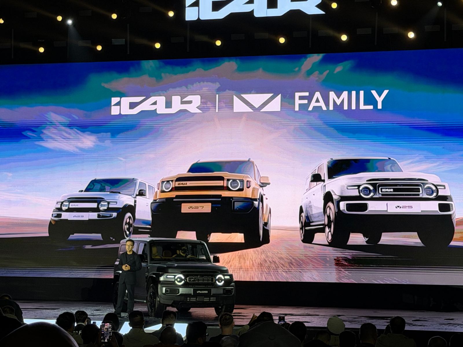 Su Jun on stage in Wuhu with the iCAUR V23, V27 and V25 on screen