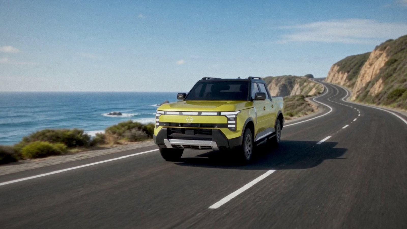 Yellow Nissan Navara Pro PHEV ute driving on a coastal road, front view