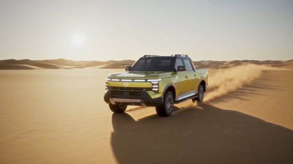Yellow Nissan Navara Pro PHEV ute driving through sand dunes