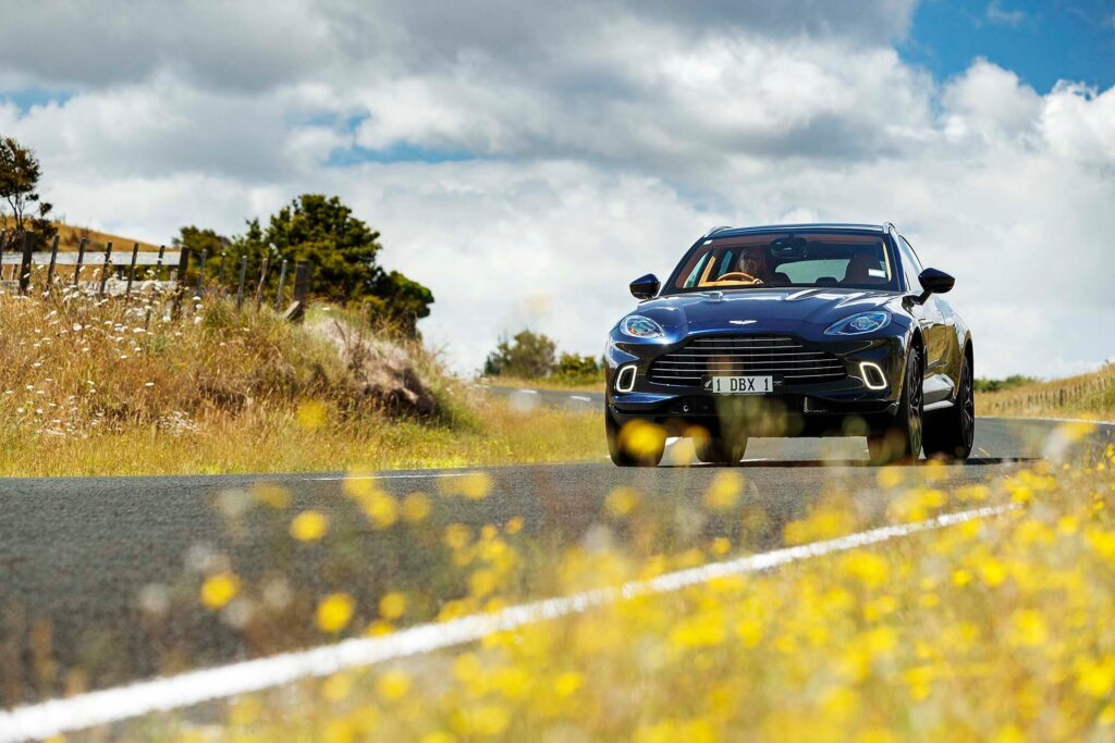 2022 Aston Martin DBX on road with flowers in foreground