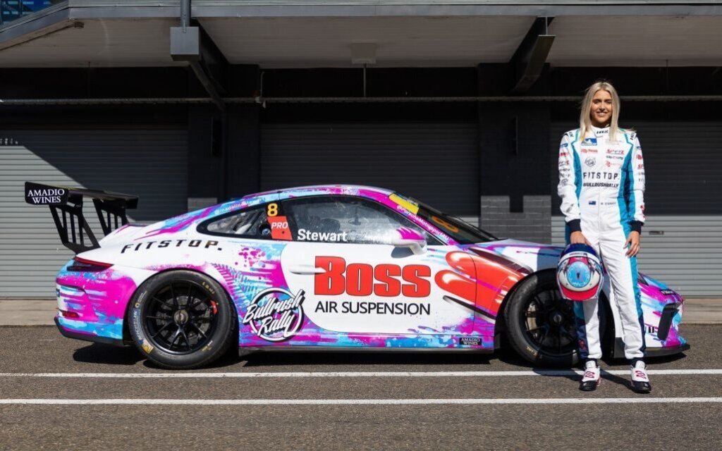 Madeline Stuwart standing by Porsche 911 race car