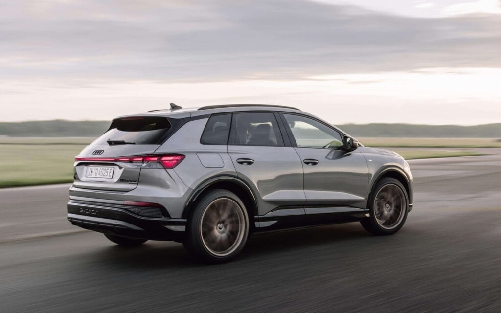 Audi Q4 e-tron SUV rear three quarter view driving on runway
