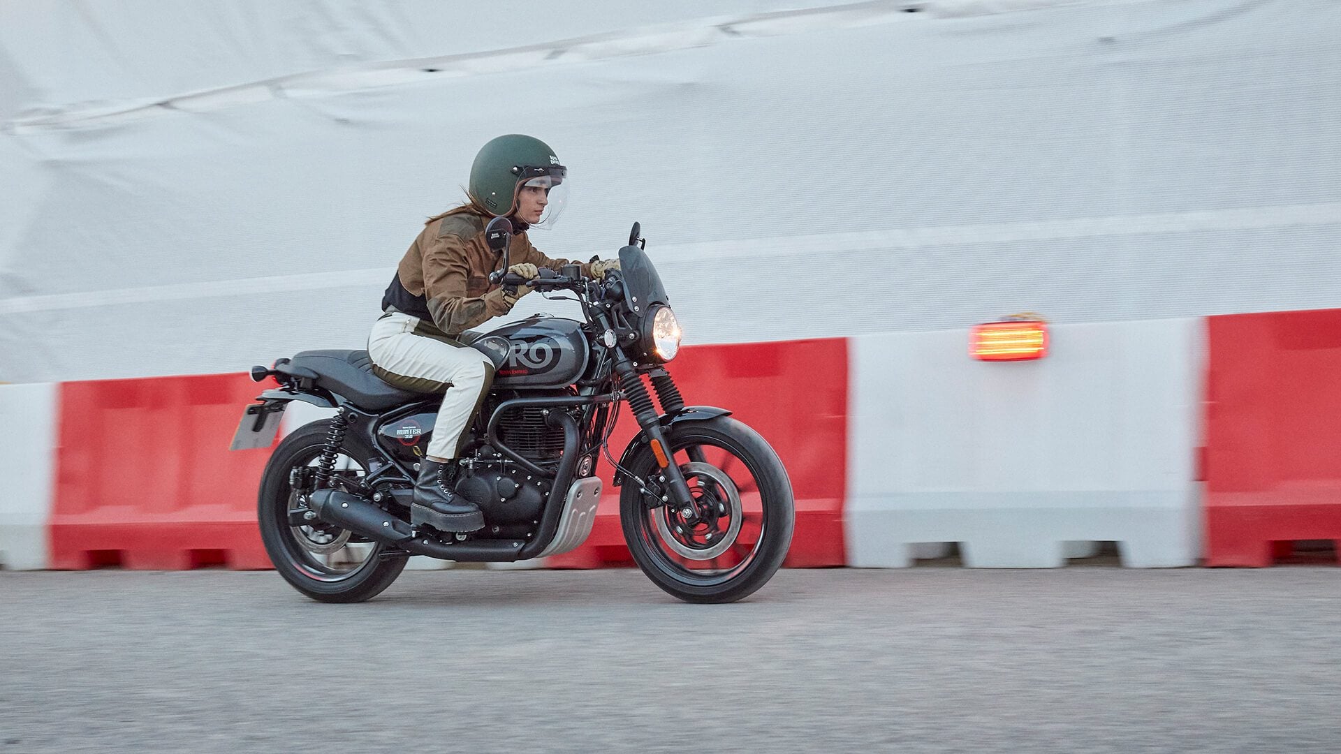 Royal Enfield Hunter 350 riding past coloured wall