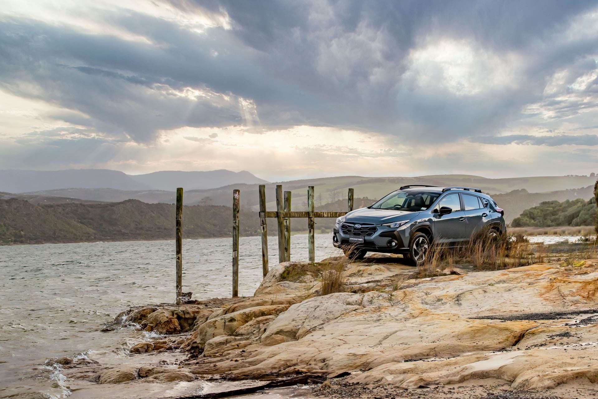 Subaru Crosstrek parked on rocks next to the sea