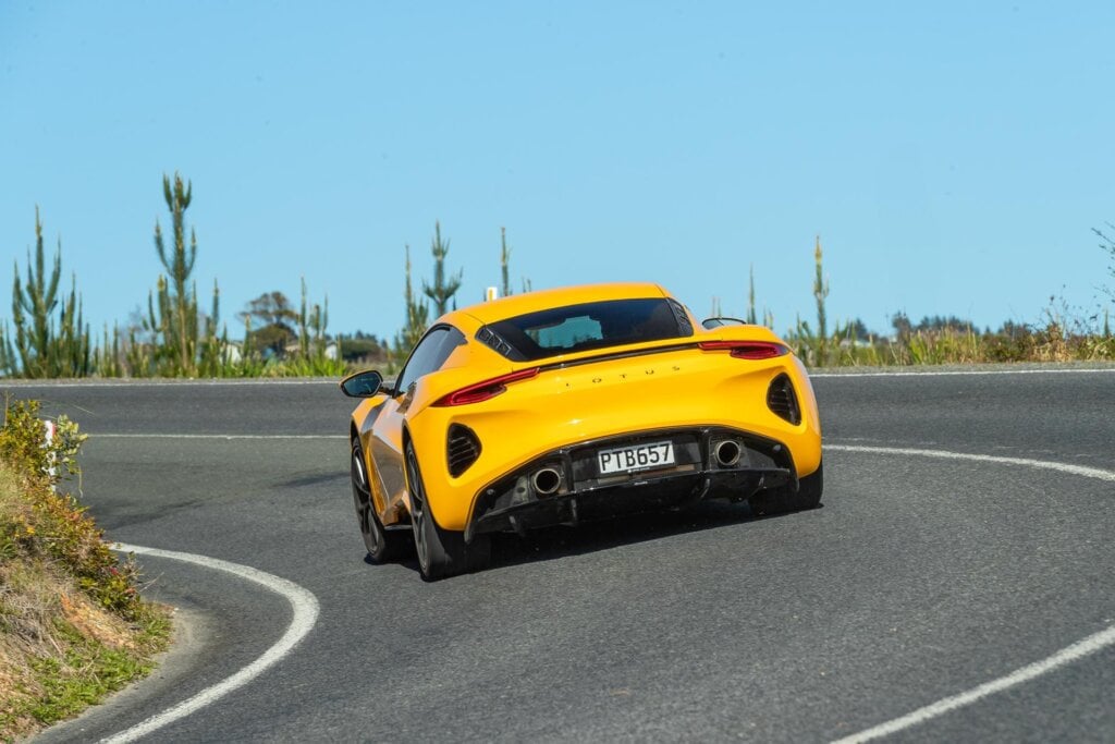 Lotus Emira V6 taking a corner, shown from the rear