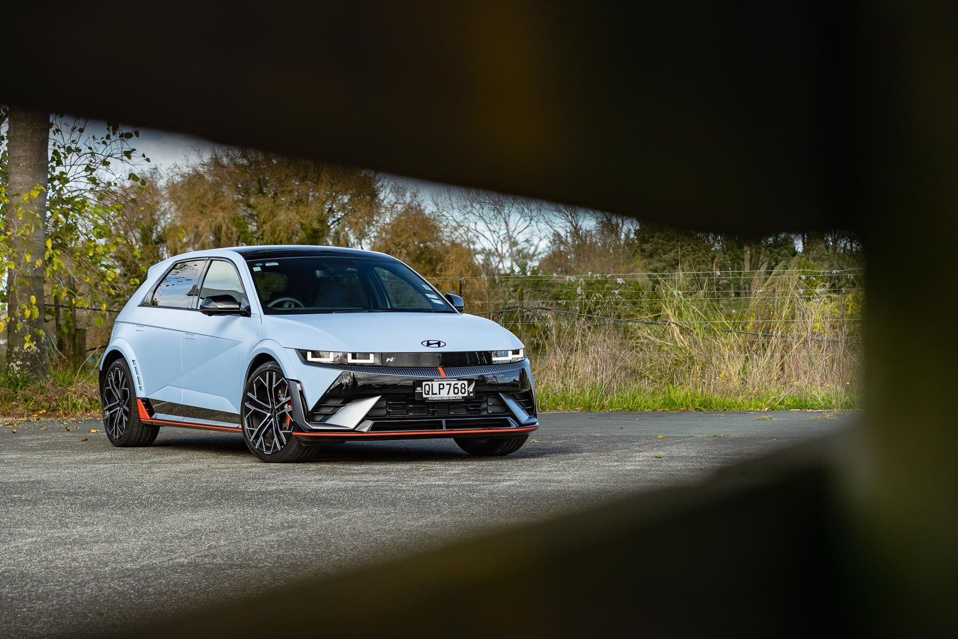 Hyundai IONIQ 5 N in blue, front quarter shot, framed by a fence