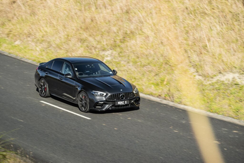 Vantage point view of the 2024 Mercedes-AMG C 63 E Performance driving past
