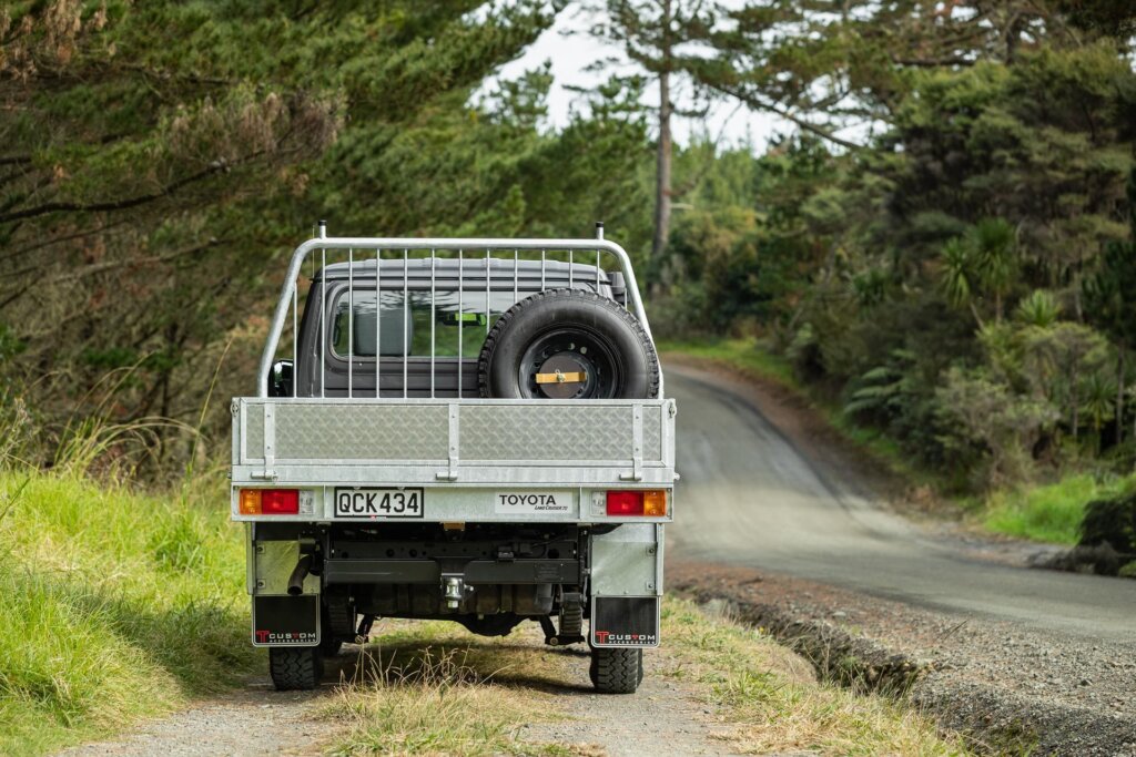 Toyota Land Cruiser 70 LT Double Cab rear profile, parked in a forest