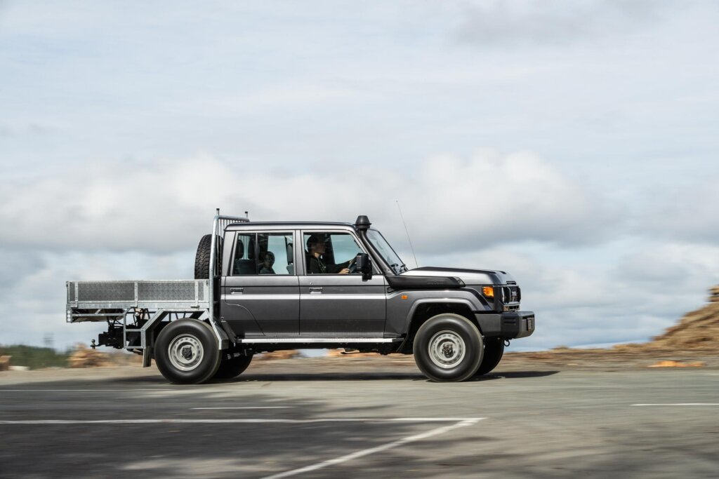 Side panning shot of the Toyota Land Cruiser 70 LT Double Cab on a forestry road
