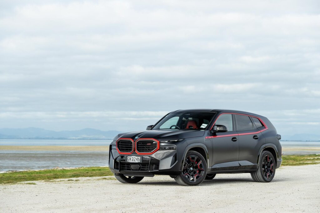 BMW XM Label Red edition parked on a white sand beach