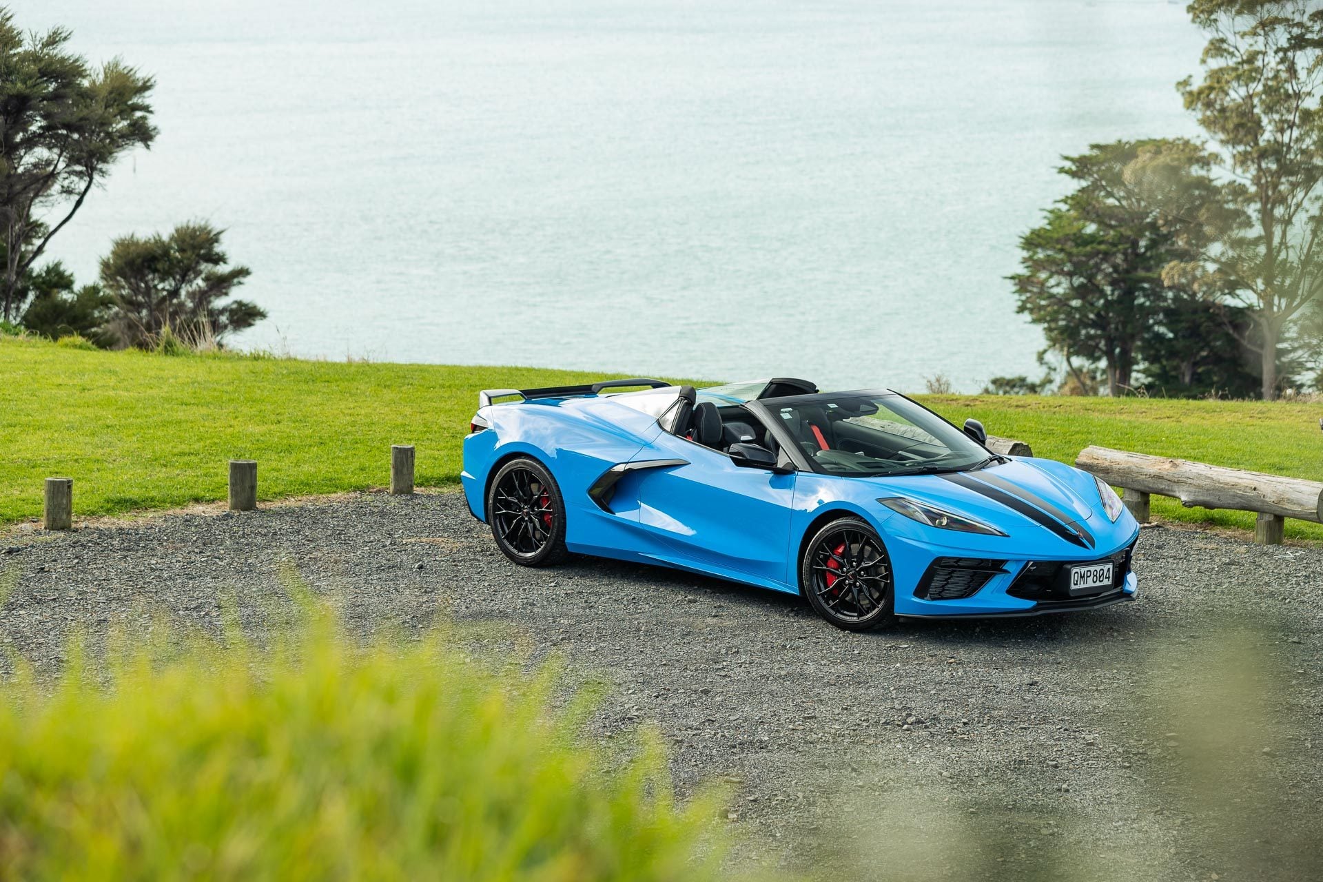 Chevrolet Corvette Stingray 3LT convertible in blue, parked with an ocean view behind
