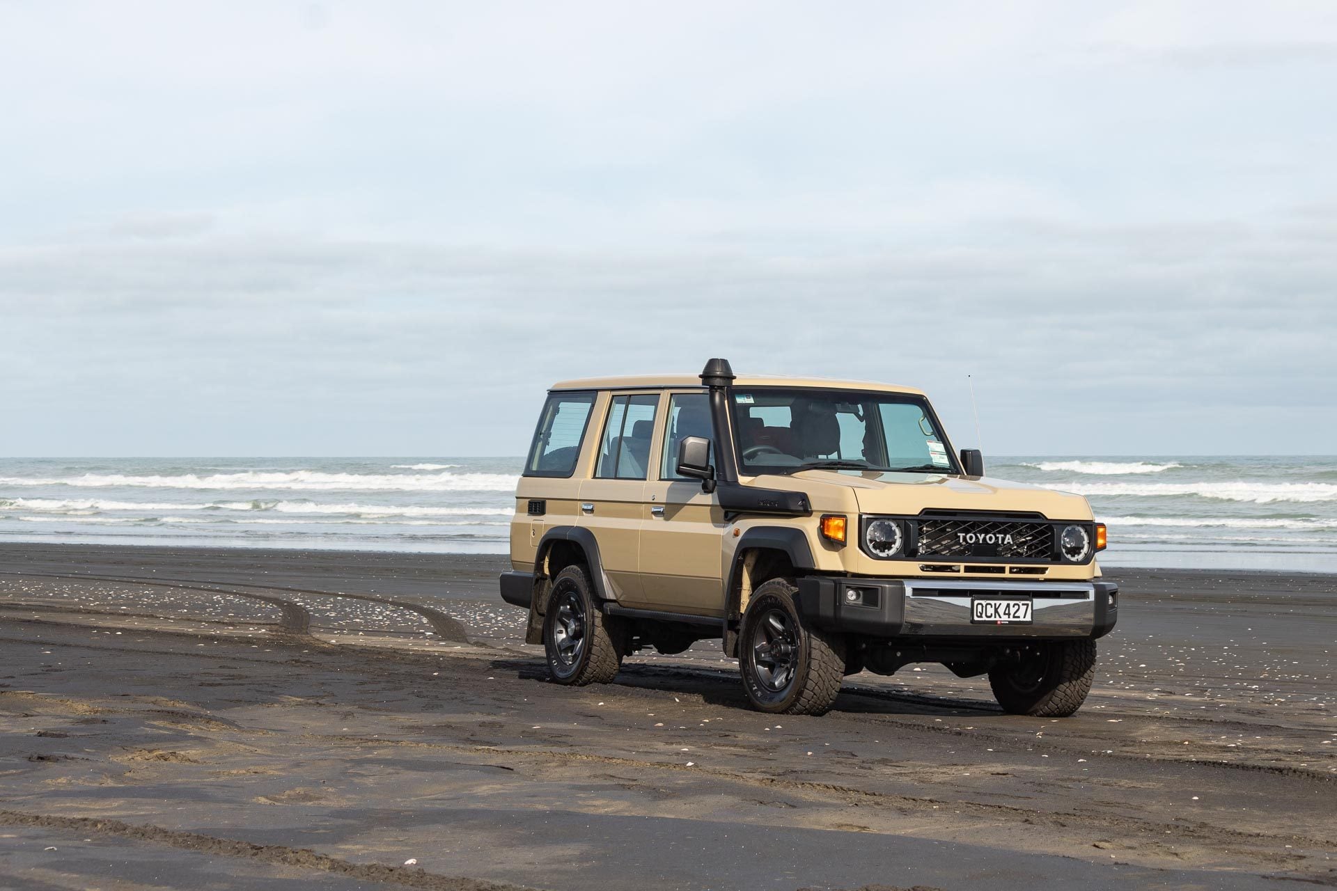 Toyota Land Cruiser 70 LX Wagon, parked on a New Zealand beach