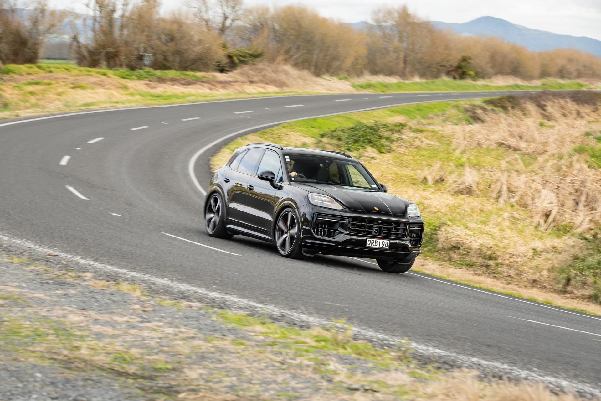 Porsche Cayenne GTS taking a corner at pace on a backroad
